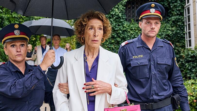 "Mama ist die Best(i)e": Gloria Almeda (Adele Neuhauser) wird von Polizisten abgef&uuml;hrt, weil sie verd&auml;chtigt wird, ihren Ehemann Viktor umgebracht zu haben.