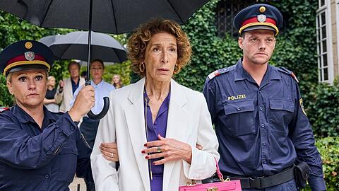 "Mama ist die Best(i)e": Gloria Almeda (Adele Neuhauser) wird von Polizisten abgef&uuml;hrt, weil sie verd&auml;chtigt wird, ihren Ehemann Viktor umgebracht zu haben.