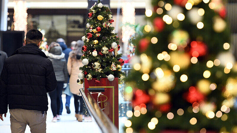 Passanten gehen in Berlin durch eine weihnachtlich geschmückte Einkaufspassage. Kunden haben am dritten Advent die Möglichkeit, auch am Sonntag noch Weihnachtseinkäufe zu erledigen.