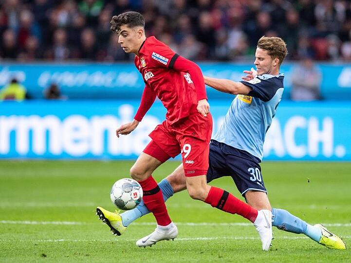 Leverkusens Kai Havertz (l) im Duell mit Gladbachs Nico Elvedi.
