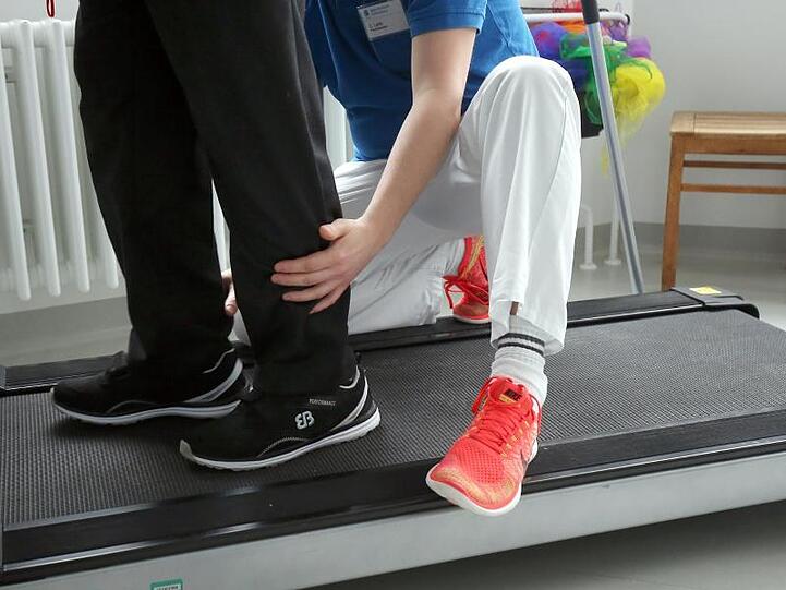 Ein Physiotherapeut hilft einem Patienten. Foto: Wolfgang Kumm/Archivbild