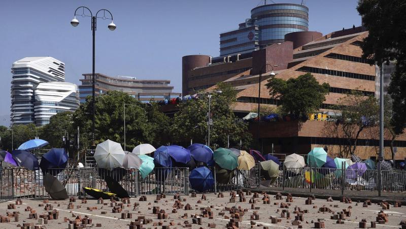 Auf einer Straße vor einer Barrikade, die von Demonstranten der Polytechnischen Universität Hongkong gebaut wurde, sind Ziegelsteine verstreut.