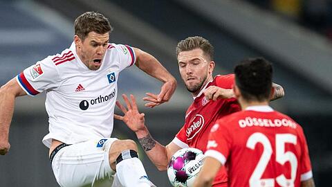 Düsseldorfs André Hoffmann (M) und HSV-Torjäger Simon Terodde teilten sich im Spitzenspiel die Punkte.