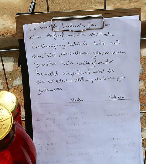 Vor dem Trümmerhaufen haben die Anwohner einen improvisierten Traueraltar aufgebaut.