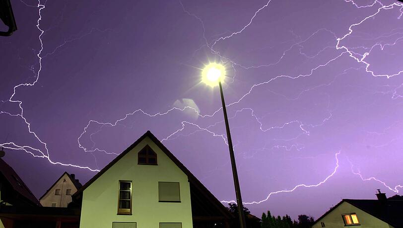 Zahlreiche Blitze sind über einem Wohnhaus zu sehen.