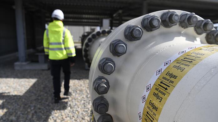 Ein Mitarbeiter geht an einem Teil einer Erdgasleitung am Gelände der Gas Connect Austria Verdichterstation.