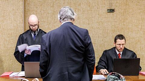 Der Angeklagte vor dem Beginn des Prozesses. Im Hintergrund seine Anwälte.