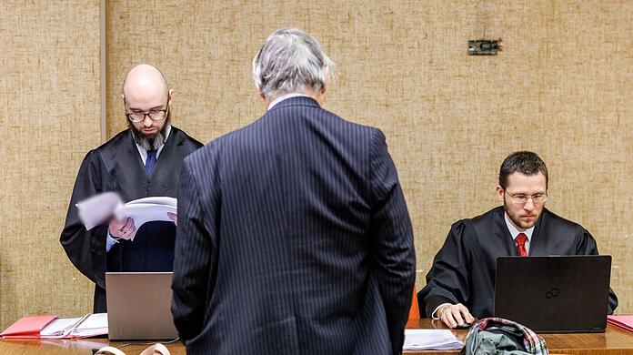 Der Angeklagte vor dem Beginn des Prozesses. Im Hintergrund seine Anwälte.