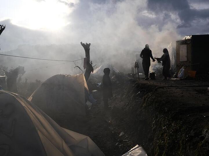 Migranten stehen vor provisorisch errichteten Zelten außerhalb des Lagers Moria. Der Bau neuer weiterer Lager stößt auf heftige Proteste.