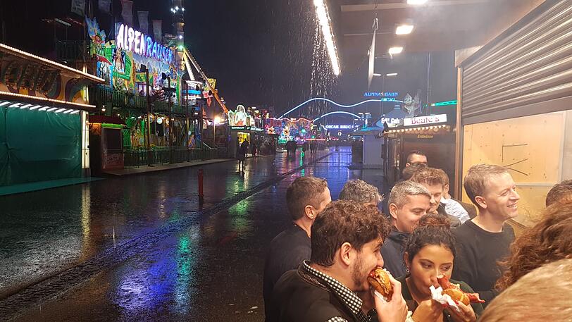 Die Wiesn-Besucher stellten sich unter, wo es ging - und nutzten das Unwetter für die ein oder andere Bratwurst.