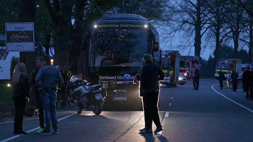 Der Bus von Borussia Dortmund steht mit einer beschädigten Scheibe in Dortmund an einer Straße.