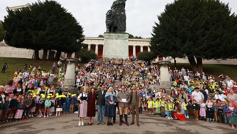 Mit gelben Westen und Helmen versammeln sich die 1500 Kindl unter der Bavaria Statue auf der Wiesn.