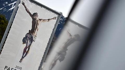 Ein Werbeplakat für die Passionsspiele 2020 spiegelt sich in einen Autofenster. Foto: Angelika Warmuth/Archivbild