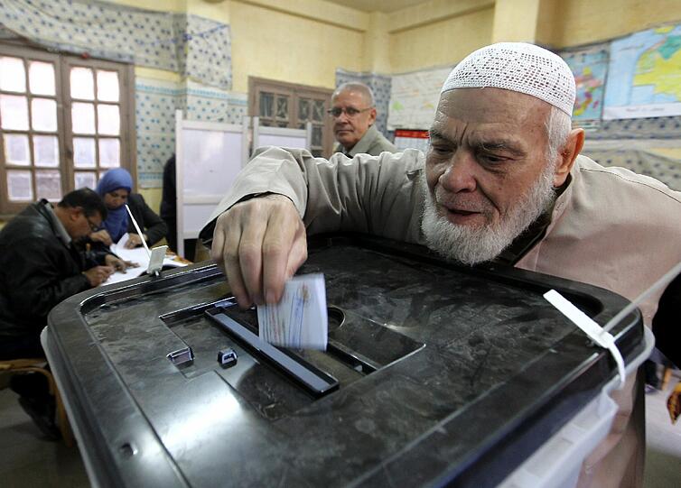 Ein Ägypter wirft seinen Stimmzettel in die Wahlurne.
