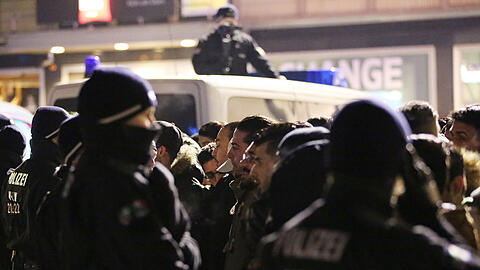 Polizisten kontrollieren in der Silvesternacht vor dem Hauptbahnhof in Köln Personen.