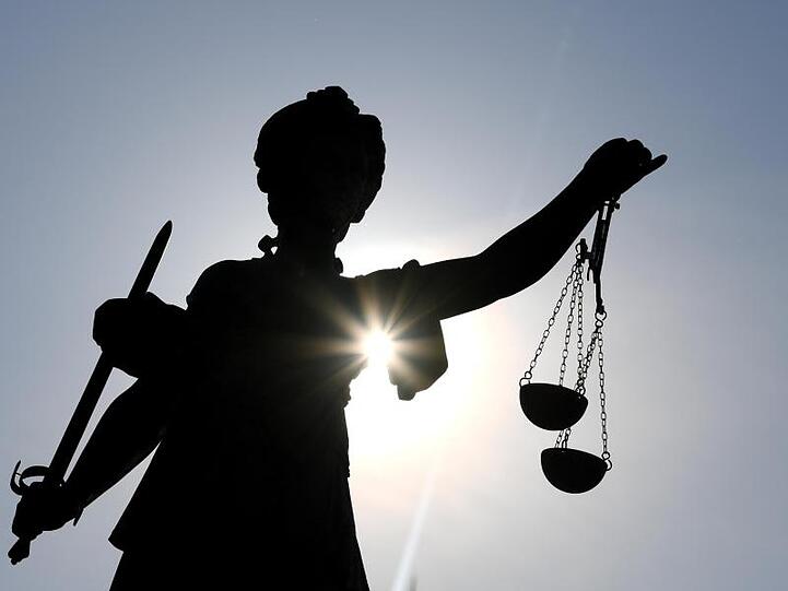 Die Statue der Justitia mit einer Waage und einem Schwert in der Hand. Foto: Arne Dedert/dpa/illustration
