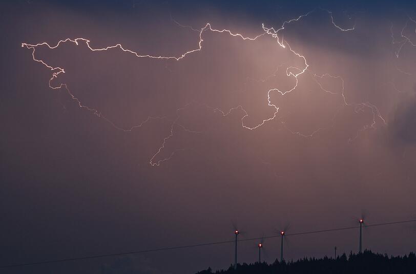 Blitze zucken am 24.07.2015 über Windrädern bei Freiburg (Baden-Württemberg).