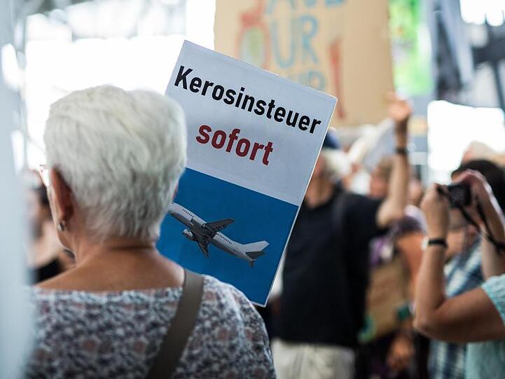 "Kerosinsteuer sofort" steht auf dem Schild einer Aktivistin.