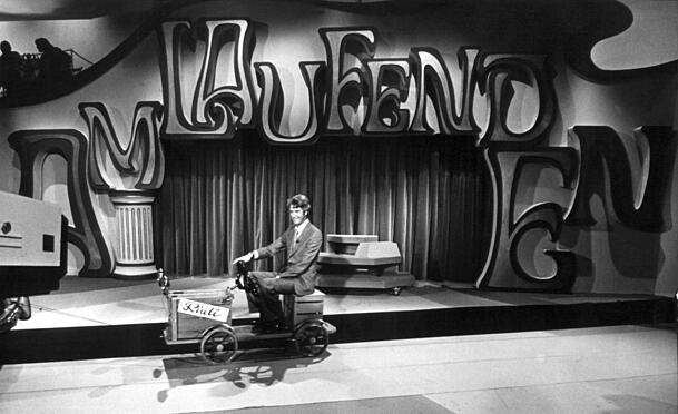 Moderator Rudi Carrel fährt während der Proben zu seiner Show "Am laufenden Band" mit einem Gefährt durch das Fernsehstudio. Moderator Rudi Carrel fährt während der Proben zu seiner Show "Am laufenden Band" mit einem Gefährt durch das Fernsehstudio.