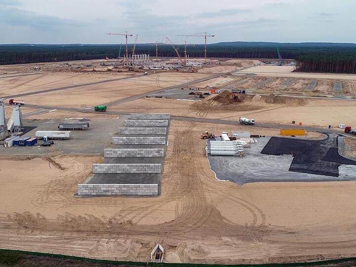 Kräne und erste Pfeiler für die künftigen Tesla Giga-Factory sind auf dem Baugelände zu sehen.