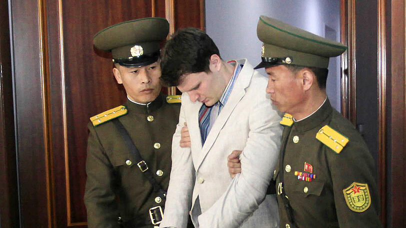 Der US-Bürger Otto Warmbier (m.) wird am 16. März 2016 in einem Gericht in Pjöngjang von zwei nordkoreanischen Polizisten eskortiert.