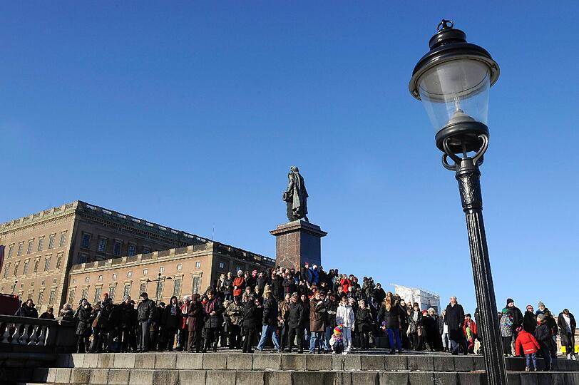 Vor dem schwedischen Königspalast in Stockholm feiert eine Menschenmenge die Nachricht von Victorias Niederkunft.