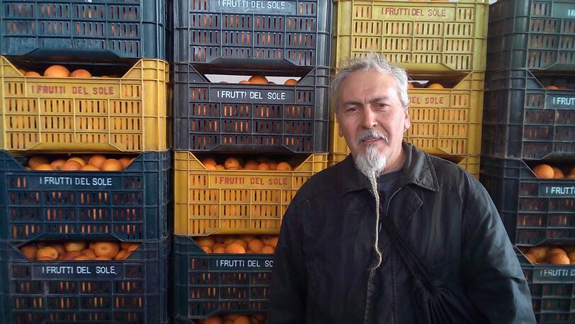 Nino Quaranta von der sozialen Organisation SOS Rosarno steht vor Orangenkisten in seiner Pflückanlage. SOS Rosarno bietet auch Migranten faire Arbeitsbedingungen bei der Ernte von Zitrusfrüchten.