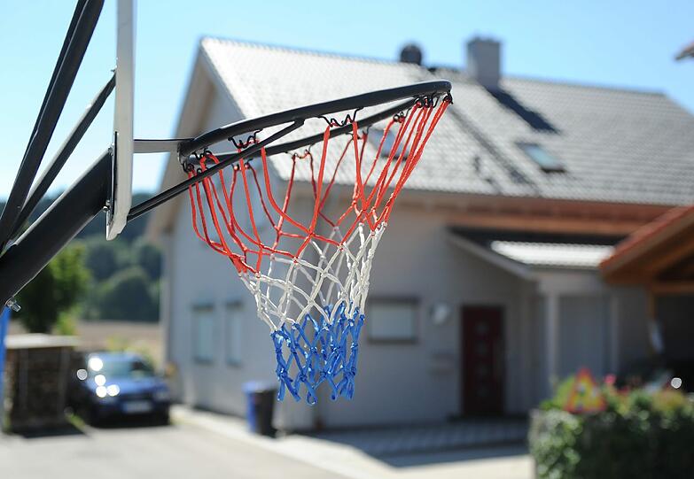 Ein Basketballkorb vor dem Haus.