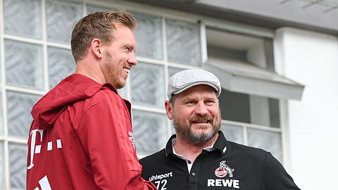 Bayerns Trainer Julian Nagelsmann (l) und Kölns Trainer Steffen Baumgart unterhalten sich.