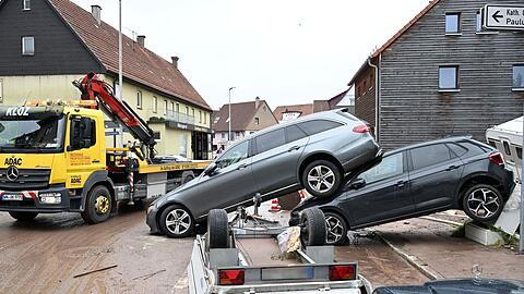 Auf einer Straße in Miedelsbach im Rems-Murr-Kreis (Baden-Württemnerg) stehen Fahrzeuge, die vom Hochwasser weggespült wurden.