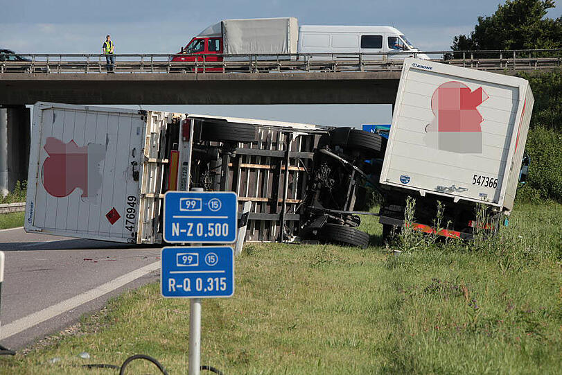 Vermutlich weil er zu schnell auf die Autobahn fährt, kommt ein Laster in der Kurve von der Fahrbahn ab und fährt in die Leitplanke. Sein Hänger kippt um.