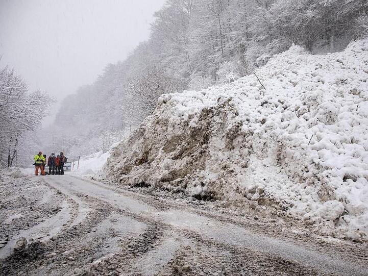 Einsatzkräfte räumen im Berchtesgadener Land nach einer Lawine eine Straße frei.