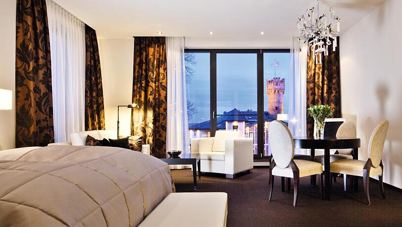 Blick in eine elegante Junior-Suite des Hotels Burg Schwarzenstein mit stilvollem Interior-Design und gemütlicher Atmosphäre. Blick in eine elegante Junior-Suite des Hotels Burg Schwarzenstein mit stilvollem Interior-Design und gemütlicher Atmosphäre.