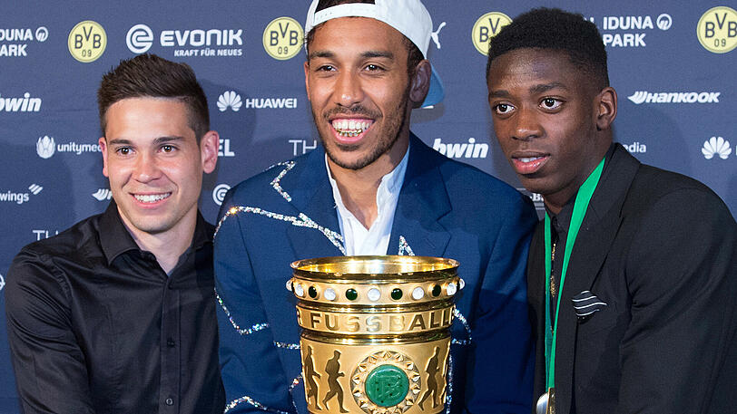 Bleibt er der Dortmunder Familie weiterhin erhalten? Pierre-Emerick Aubameyang nach dem DFB-Pokalsieg mit den Teamkollegen Raphaël Guerreiro und Ousmane Dembélé