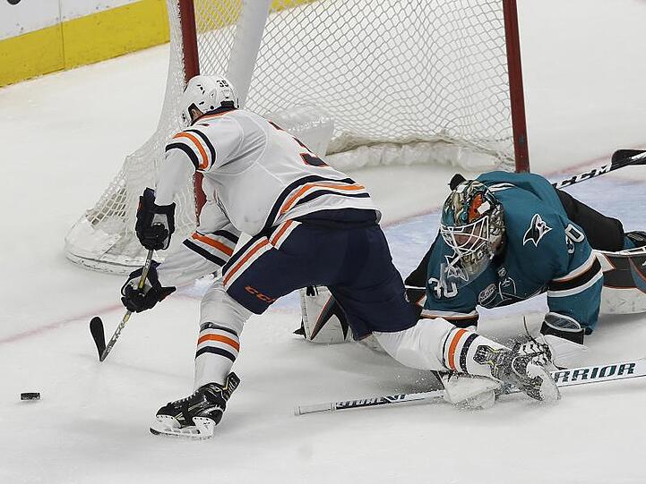 Goalie Aaron Dell (r) von den San Jose Sharks kann einen Angriff von Oilers-Spieler Alex Chiasson abwehren.