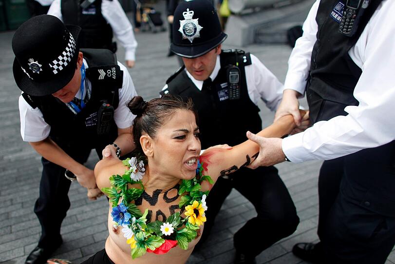 Nackte Tatsachen: Gewohnt freizügig protestierten Anhänger der feministischen Organisation Femen in London während Olympia - diesmal gegen islamistische Regimes und deren Unterstützung durch das olympische Kommitee. Da hatte die englische Polizei alle Hände voll zu tun.