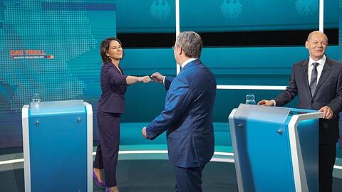 Die Kanzlerkandidaten Armin Laschet (mitte, CDU), Annalena Baerbock (l., Bündnis 90/Die Grünen) und Olaf Scholz (SPD) begrüßen sich vor der Sendung im Fernseh-Studio in Berlin-Adlershof.