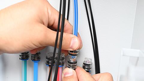 Ein Techniker verbindet Glasfaser-Kabel, um besonders schnelles Internet zu erm&ouml;glichen.