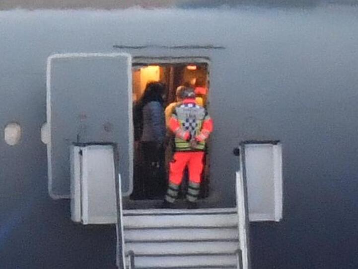 Rettungskräfte mit Schutzkleidung im Bundeswehr-Flugzeug. Foto: Boris Roessler/dpa