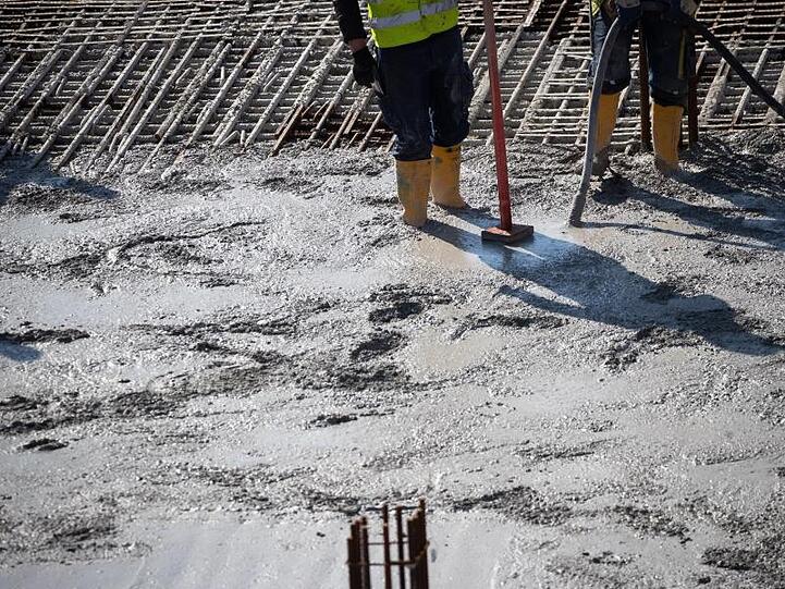 Betonbauer verarbeiten frischen Beton auf einer Baustelle in der Hafencity.
