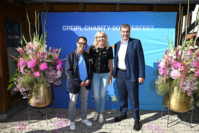 Münchens Charity-Queen Saskia Greipl-Kostantinidis mit Mann Stavros Kostantinidis (l.) und Ministerpräsident Markus Söder beim zehnten Greipl-Charity-Sommerfest im Ismaninger Fußballstadion. Münchens Charity-Queen Saskia Greipl-Kostantinidis mit Mann Stavros Kostantinidis (l.) und Ministerpräsident Markus Söder beim zehnten Greipl-Charity-Sommerfest im Ismaninger Fußballstadion.