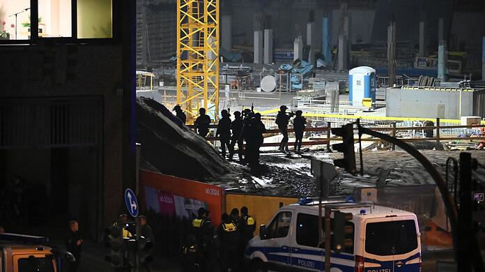 Polizisten in Spezialausr&uuml;stung stehen neben einem Geb&auml;ude der Zeugen Jehovas.