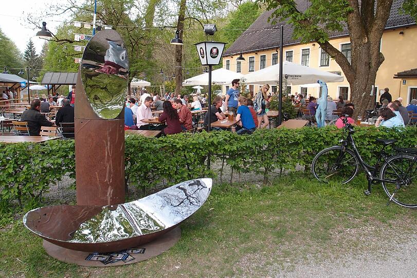 Kunst im Biergarten: Hinter der Skulptur "Hänsel und Gretel" blitzt der Maibaum. Vorne ist das Windspiel zum Spielen für die Kinder.