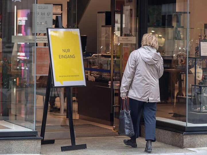 Eine Frau betritt ein Geschäft in München durch eine Tür, neben dem ein Schild mit der Aufschrift "Nur Eingang" steht. Foto: Peter Kneffel/dpa/Archivbild