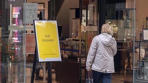 Eine Frau betritt ein Geschäft in München durch eine Tür, neben dem ein Schild mit der Aufschrift "Nur Eingang" steht. Foto: Peter Kneffel/dpa/Archivbild