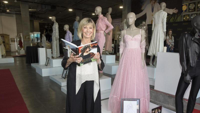 Olivia Newton-John steht neben einigen der Objekte, die zur Auktion angebopten werden. Olivia Newton-John steht neben einigen der Objekte, die zur Auktion angebopten werden.