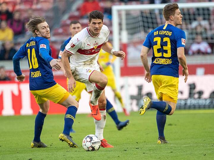 Stuttgarts Mario Gomez (M) kämpft gegen Leipzigs Emil Forsberg (l) und Marcel Halstenberg (r) um den Ball.