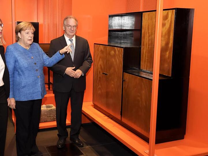 Reiner Haseloff (CDU, l), Ministerpräsident von Sachsen-Anhalt, und Bundeskanzlerin Angela Merkel (CDU) machen einen kleinen Rundgang durchs neue Bauhaus Museum in Dessau.