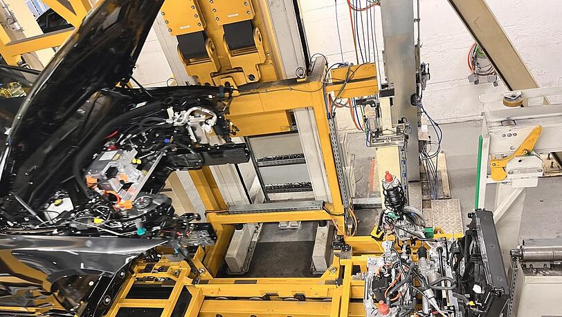Die Hochzeit eines E-Autos: Das Fahrwerk und die Karosserie werden zusammengeführt. Anders als beim Verbrenner besteht die Antriebseinheit aus zwei Teilen. Die Hochzeit eines E-Autos: Das Fahrwerk und die Karosserie werden zusammengeführt. Anders als beim Verbrenner besteht die Antriebseinheit aus zwei Teilen.