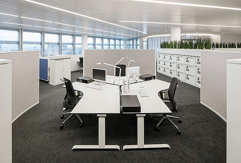 So schauen Arbeitsplätze für Teamwork aus. Im Hintergrund rechts sind Mitarbeiter-Schließfächer ("Locker") zu sehen.